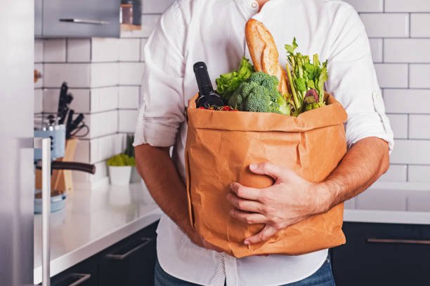 istock Man holding paper bag with different vegetable and other products 1177448763