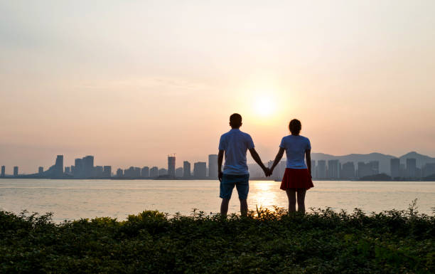 istock Couple holding hands on the beach at sunset 1177448929
