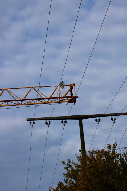 istock Construction crane passes with safety distance under a power line 1177449205