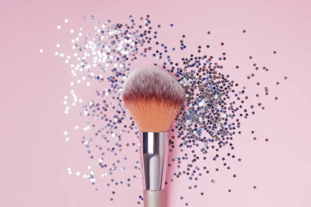 istock Make-up brush and star shaped confetti on pink backround, top view. 1177450877
