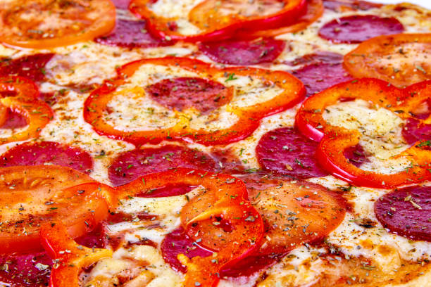 istock Pizza closeup background with pepperoni, tomatoes and bell pepper 1177451043