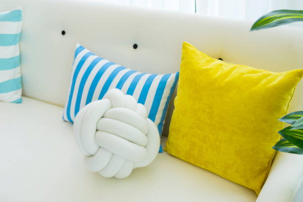 Yellow and blue pillows on white sofa at home. Modern and colorful living room.
