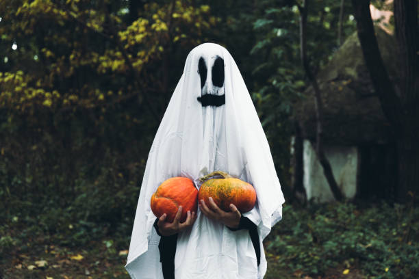 호박과 유령 의상을 입은 여자는 당신에게 행복한 할로윈을 기원합니다! - fancy costume 뉴스 사진 이미지