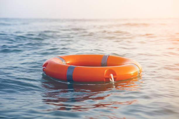 Red lifebuoy pool ring float Orange lifebuoy in sea on water. Life ring floating on top of water. Life ring in ocean.Toning. buoy stock pictures, royalty-free photos & images