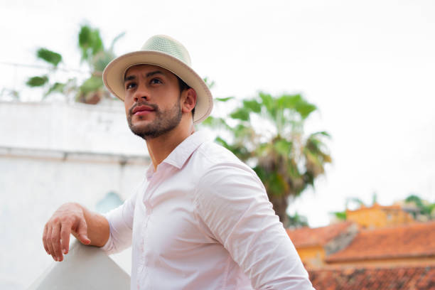 Latino man on vacation, walking, looking and smiling at a beautiful resort, enjoying his vacation
