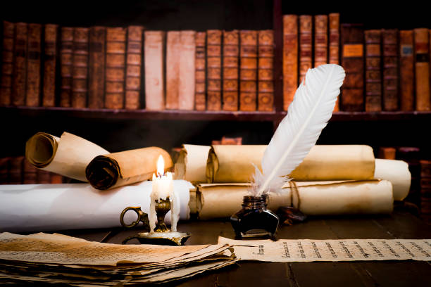 istock A lit candle against the background of blurred scrolls, books and bird feathers 1177458121