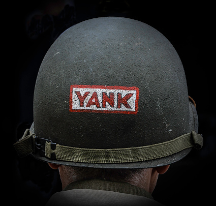 WW2 American helmet with the word 'YANK' painted on it.
