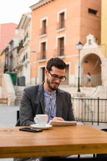istock Young businessman is writing in his notebook in a bar terrace 1177459893