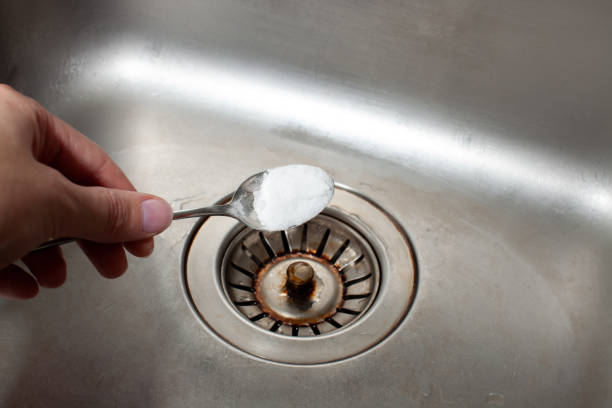 istock Baking soda in a spoon over a dirty dishwasher sink 1177460520