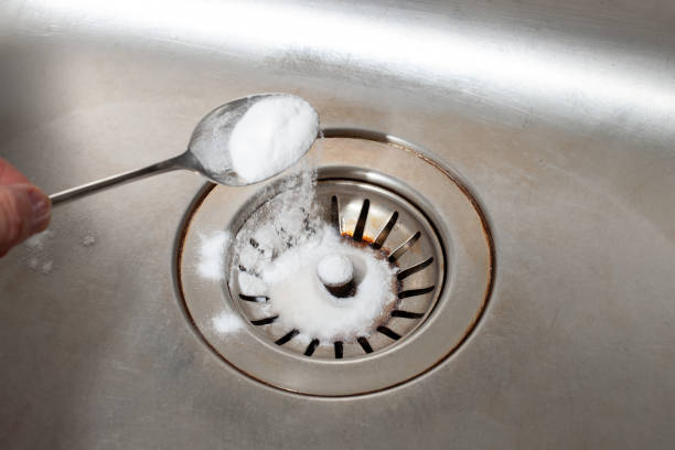 istock Baking soda in a spoon over a dirty dishwasher sink 1177460814