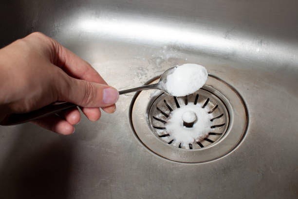 istock Baking soda in a spoon over a dirty dishwasher sink 1177460833