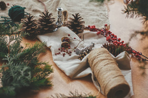 istock Fir branches, pine cones, thread, berries, cinnamon on wooden table. Rustic Christmas wreath workshop. Authentic stylish still life. Making Christmas wreath. 1177463576