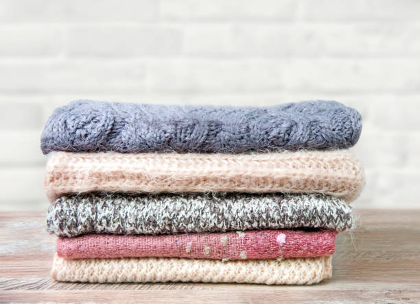 istock A stack of knitted scarves on a wooden table 1177463908
