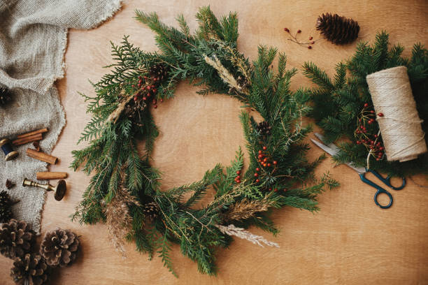 istock Rustic Christmas wreath flat lay. Fir branches, pine cones, thread, berries, scissors on wooden table. Christmas wreath workshop. Authentic stylish still life. Happy Holidays 1177465385