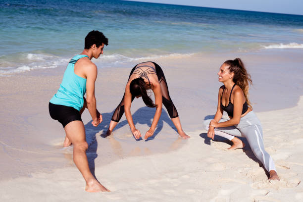 istock Three young people limbering up on the waters edge 1177465482