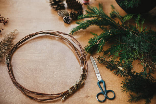 istock Making christmas wreath.Fir branches, pine cones, thread, scissors, wooden circle, berries and herbs for rustic wreath on wooden table. Details for workshop of making christmas wreath 1177466129