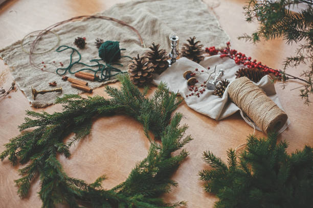 istock Making Christmas wreath. Fir branches, pine cones, thread, berries, cinnamon on wooden table. Rustic Christmas wreath workshop. Authentic stylish still life 1177466259