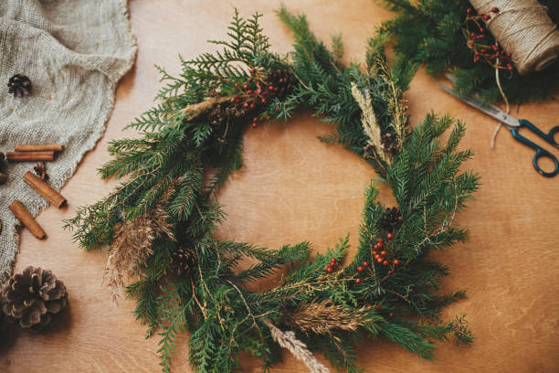istock Rustic Christmas wreath flat lay. Fir branches, pine cones, thread, berries, scissors on wooden table. Christmas wreath workshop. Authentic stylish still life. Happy Holidays 1177467533