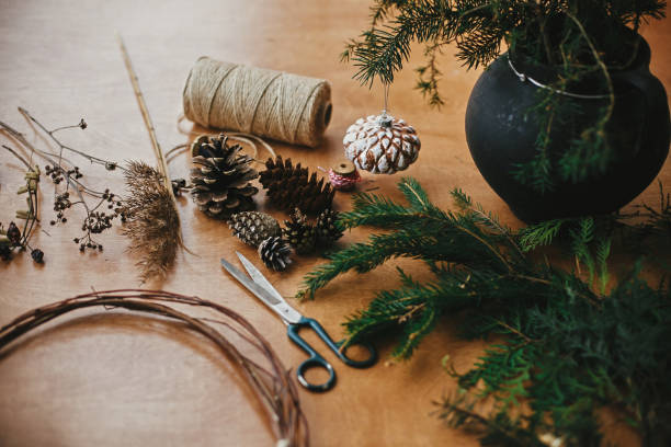 istock Making christmas wreath.Fir branches, pine cones, thread, scissors, wooden circle, berries and herbs for rustic wreath on wooden table. Details for workshop of making christmas wreath 1177469658