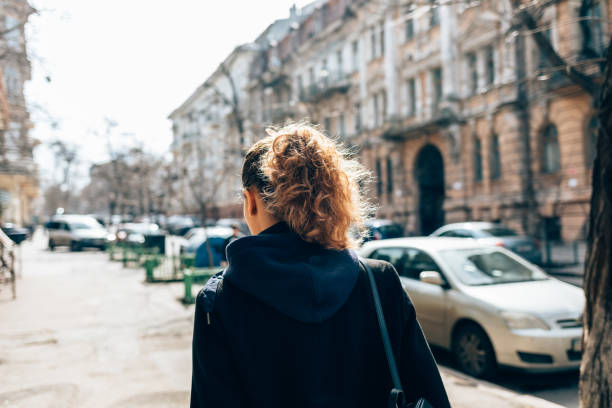 istock Rear view young woman in black coat 1177478010