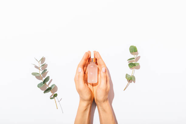 Woman's hands holding bottle of cosmetic serum