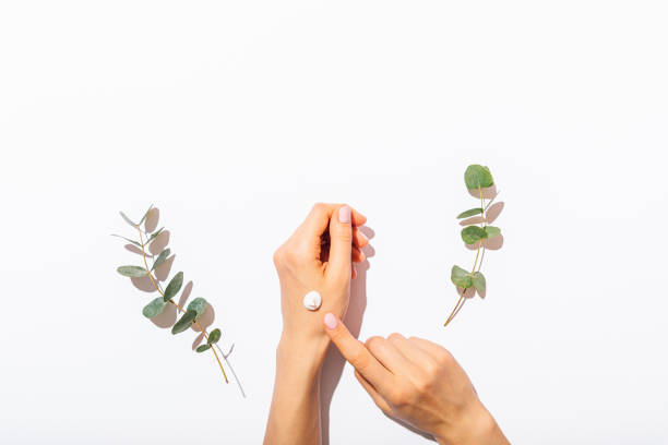 Woman's hands apply cosmetic cream