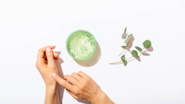 manos femeninas aplicando gel de aloe vera - leaf epidermis fotografías e imágenes de stock