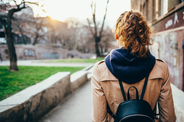 istock Young woman in a beige coat with a backpack 1177478119