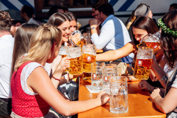 visitantes que comemoram oktoberfestfest na barraca da cerveja, munich, alemanha - lederhosen oktoberfest beer dancing - fotografias e filmes do acervo