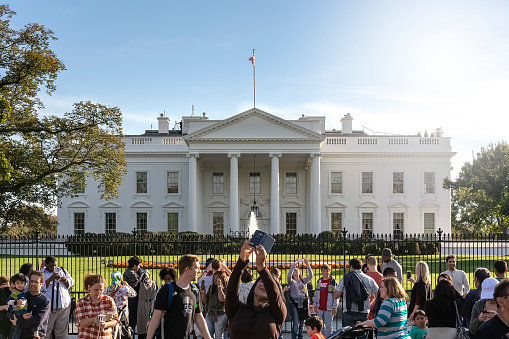 Washington D.C. USA, October 2016: tourists taking photos in front of the White House on a sunny day. Tourism and travel