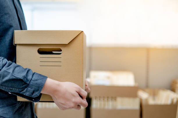 istock Courier man carrying box shopping in warehouse 1177479135