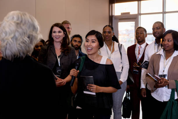istock Excited mid adult woman asks unrecognizable expo speaker question 1177480955