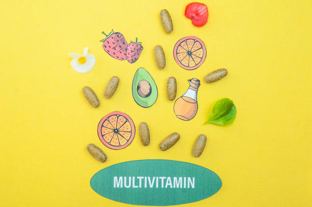 concept multivitaminici e integratori, una fontana delle loro capsule e prodotti utili su sfondo giallo - bottle capsule cod routine foto e immagini stock