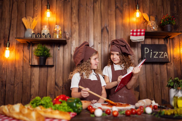 istock Little cooks reading recipe book 1177484495