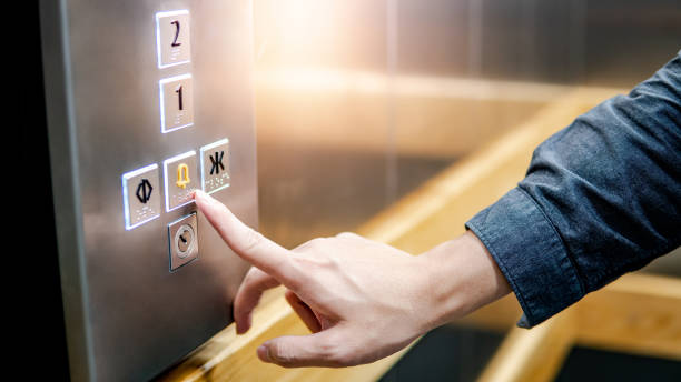 Male hand pressing on emergency button in elevator Male forefinger pressing on emergency stop and alarm button in elevator (lift). Mechanical engineering concept hand elevator stock pictures, royalty-free photos & images