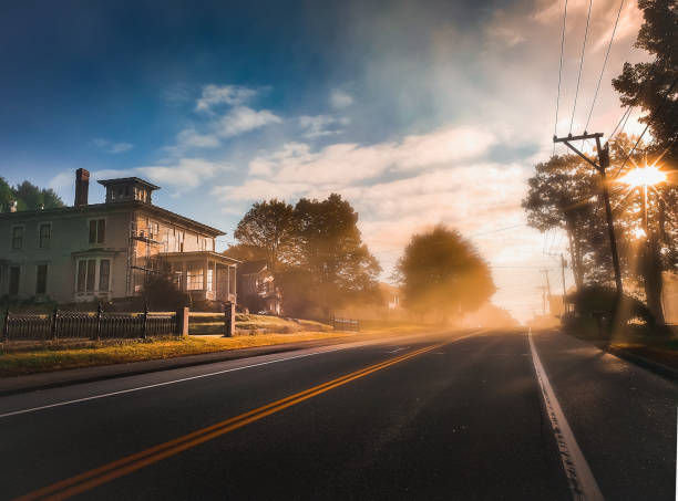 piccola città mornin' - fog road spooky mist foto e immagini stock