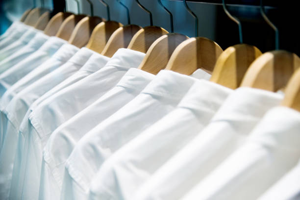 grupo de camisas brancas que penduram em ganchos - shirt button down shirt hanger clothing - fotografias e filmes do acervo