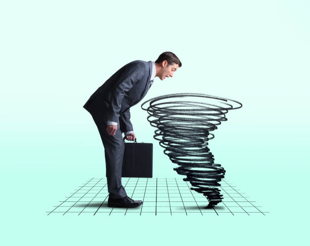 istock Businessman Looking Down Into Swirling Tornado On A Chart 1177488958