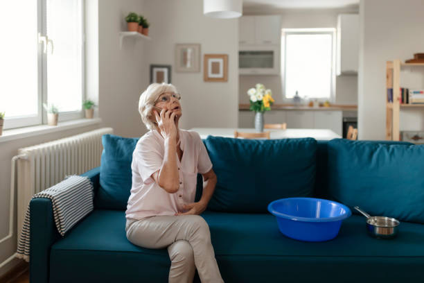 senior woman calling plumber for water leakage at home - home damage imagens e fotografias de stock