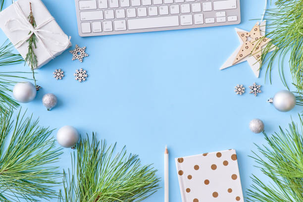 istock Flat lay christmas home office desk with pine branches and keyboard, christmas decorations on a blue background 1177491009