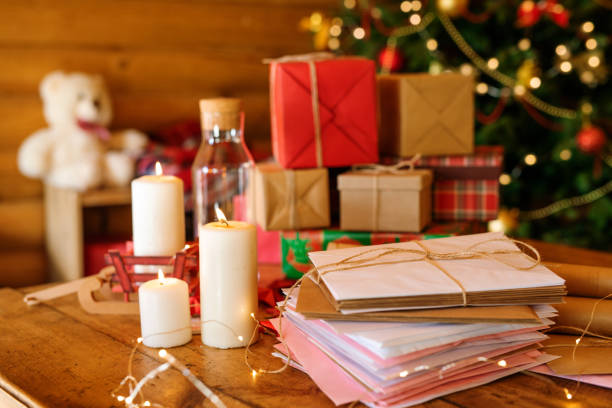 istock Stack of Christmas letters, burning candles and pile of giftboxes 1177491692