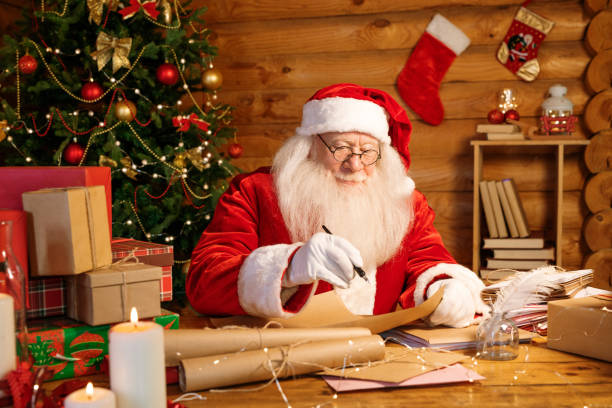 istock Santa Claus with white beard holding pen over paper while writitng letter 1177491747