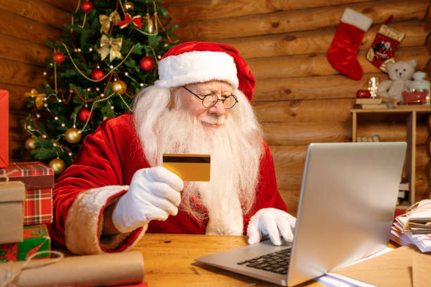 istock Gloved Santa in costume holding plastic card while making online order 1177491938