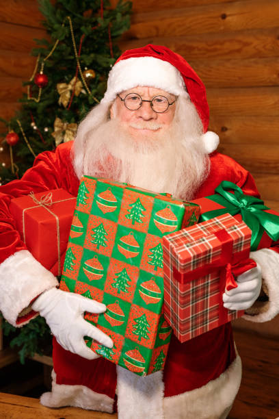 istock Happy Santa with four packed giftboxes standing in front of camera 1177491973