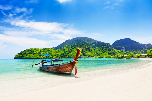 Barco tailandés tradicional de madera y hermosa playa de arena. photo