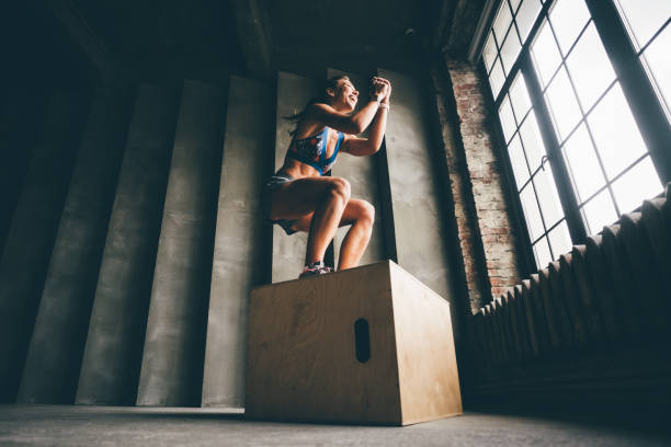 Fitness woman jumping on box. stock photo