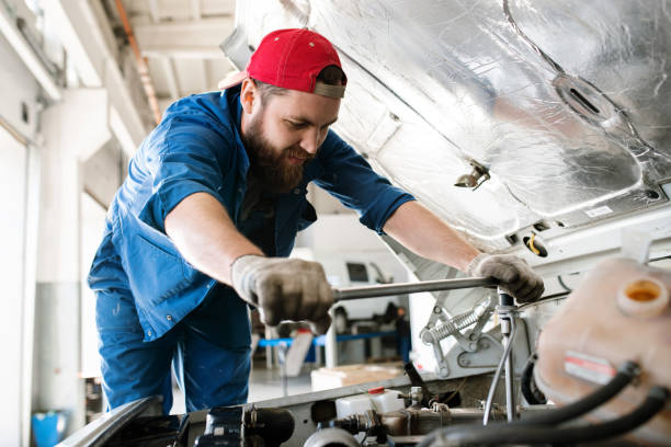 istock Young technician in workwear bending over engine of car or lorry 1177501256