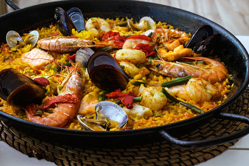 Traditional spanish seafood paella dish in a black pan. Mussels, Amandi and prawns on a pillow of rice. Close-up. Delicious wholesome dinner in a Spanish restaurant on the island of Mallorca.