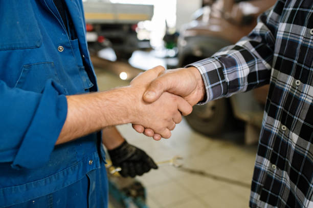 joven cliente de servicio de reparación y técnico saludarse unos a otros por apretón de manos - customer auto repair shop car mechanic fotografías e imágenes de stock