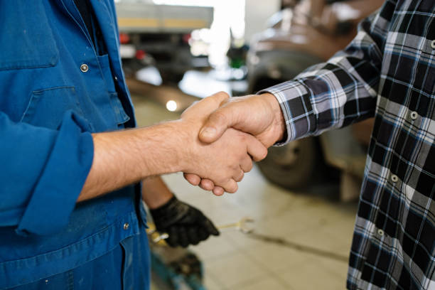 giovane cliente del servizio di riparazione e tecnico che si salutano con la stretta di mano - customer auto repair shop car mechanic foto e immagini stock